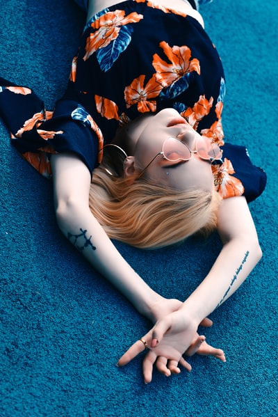 Dressed in dark blue skirt woman lying on the green textiles
